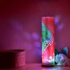 Lamp set in a cube-like shelving display Where the sides and roof capture the projected light and shadow patterns from the internal LED.