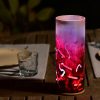 Lamp shown in an outdoor dining scene at night providing a dramatic center piece for guests.