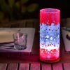 Lamp shown in an outdoor dining scene at night providing a dramatic center piece for guests.