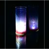 Lit only by its LED, lamp shown set on reflective black plexiglass and also as a side backdrop, lamp displays duel brilliant mirrored images. shown in three stages of rotation are arranged in a triptych.