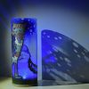 Shown under spot light at upper left, lamp displays brilliant projected color and shadow patterns. Highlighted are displays of patterns through clear glass. LED set to blue colored light.