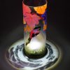 Lamp shown under spot light set directly overhead. Photo displays marvelous projected patterns of light and shadow surrounding base of lamp.