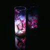 Lit only by its LED, lamp shown with reflective black plexiglass below and at the lamp’s side. Lamp displays duel brilliant mirrored images.