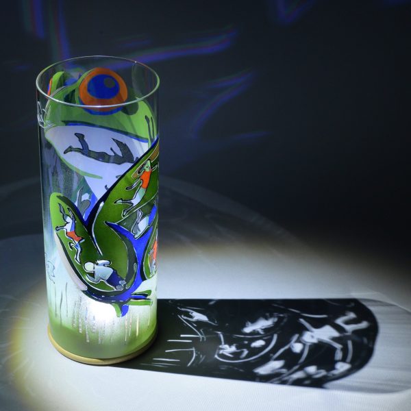Shown under spot light at upper left, lamp displays brilliant projected color and shadow patterns. Highlighted are displays of patterns through clear glass.