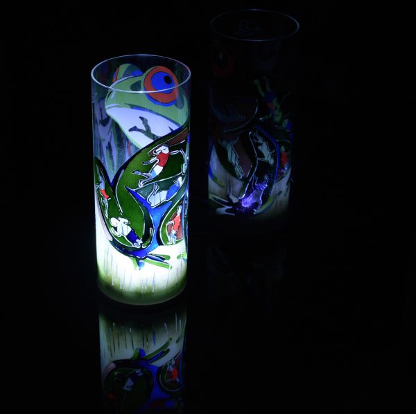 Lit only by its LED, lamp shown with reflective black plexiglass below and at the lamp’s side. Lamp displays duel brilliant mirrored images.