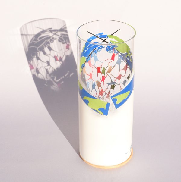 Anje Rozan art glass lamp shown under flood light displaying shadow image projected on a backdrop.