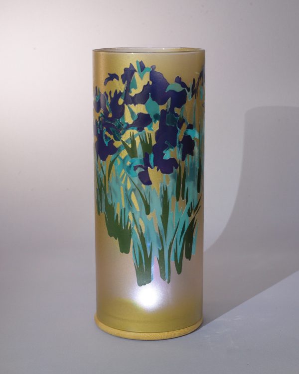 Art glass lamp shown against flood lit backdrop displaying face view.