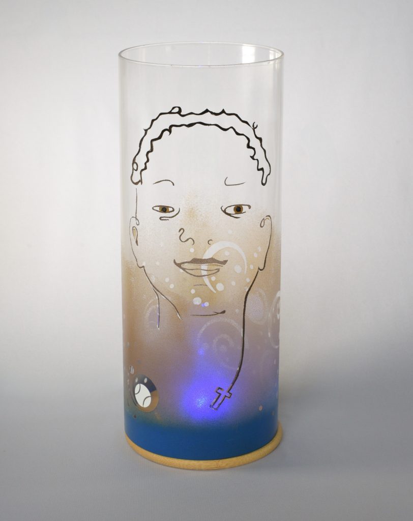 art glass lamp shown against flood lit backdrop displaying face view.