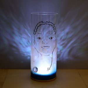 Shown with only internal LED illuminated. Unique art glass lamp displays brilliant shadow patterns on backdrop.