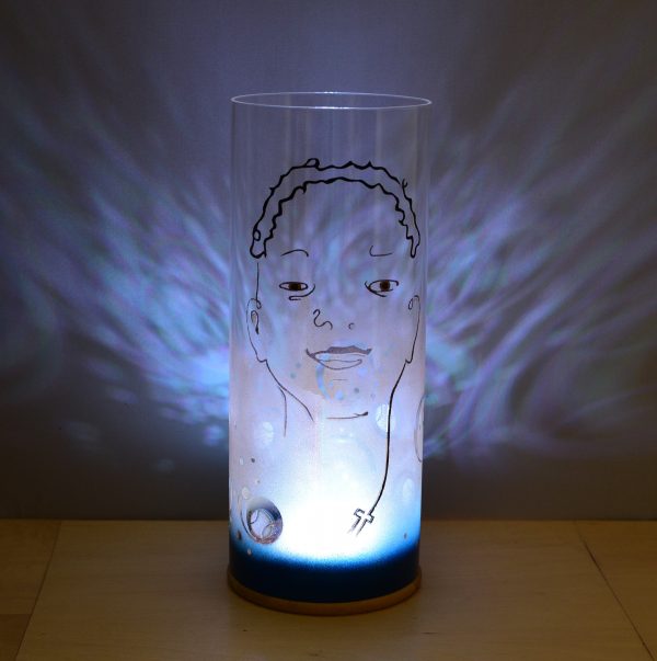 Shown with only internal LED illuminated. Unique art glass lamp displays brilliant shadow patterns on backdrop.