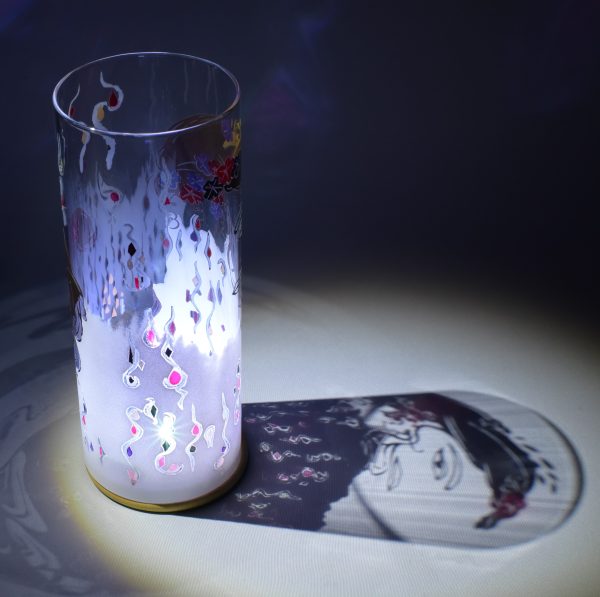Shown under spot light at upper left. Lamp displays brilliant projected color and shadow patterns. Highlighted are displays of patterns seen through clear glass.