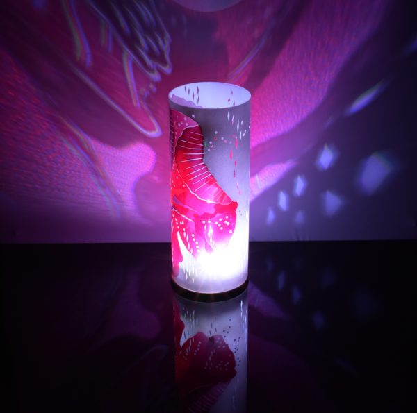 Shown on black plexiglass, using its internal LED, art glass lamp projects a stunning color pattern.
