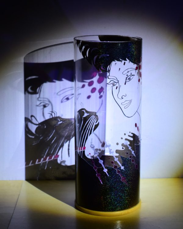 Art glass lamp shown under flood light. Ponto emphasizes the transparent colors and the superimposition of forms which transform the image.