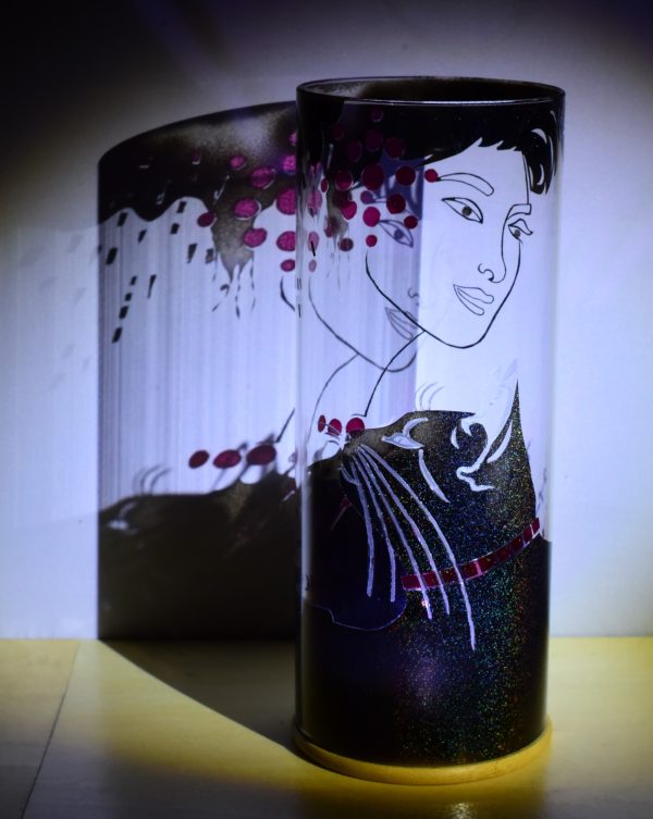 Art glass lamp shown under flood light. Ponto emphasizes the transparent colors and the superimposition of forms which transform the image.