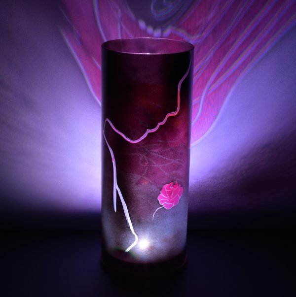Shown with only LED illuminated. Unique art glass lamp displays brilliant color patterns on backdrop.