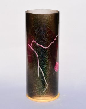 Art glass lamp shown against flood lit backdrop displaying face view.