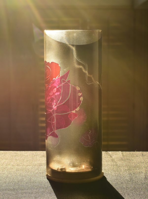 Lamp shown on display counter at sun rise bathed in full sun. Rear view/