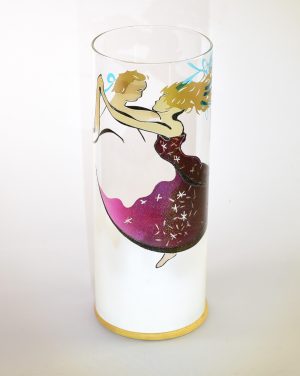Art glass lamp shown against flood lit backdrop displaying front view.