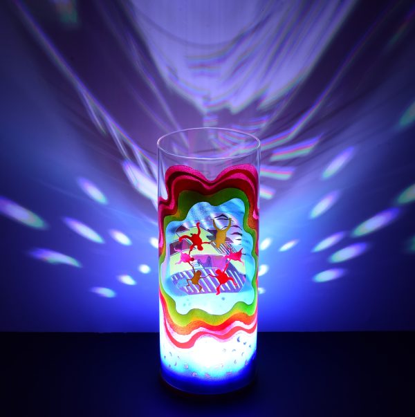 Shown with only LED illuminated. One-of-kind art glass lamp displays brilliant color patterns on backdrop.