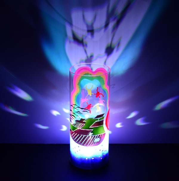 Shown with only LED illuminated. Unique art glass lamp displays brilliant color patterns on backdrop.
