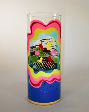 Art glass lamp shown against flood lit backdrop displaying front view.