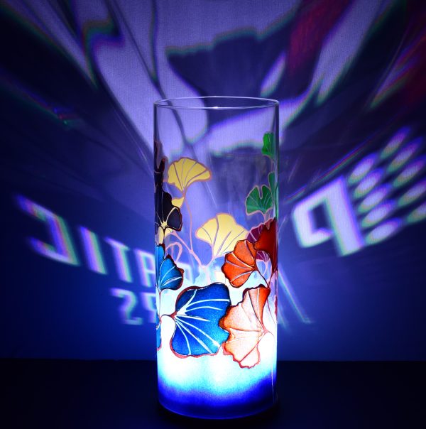 Shown with only LED illuminated. Unique art glass lamp displays brilliant color patterns on backdrop.