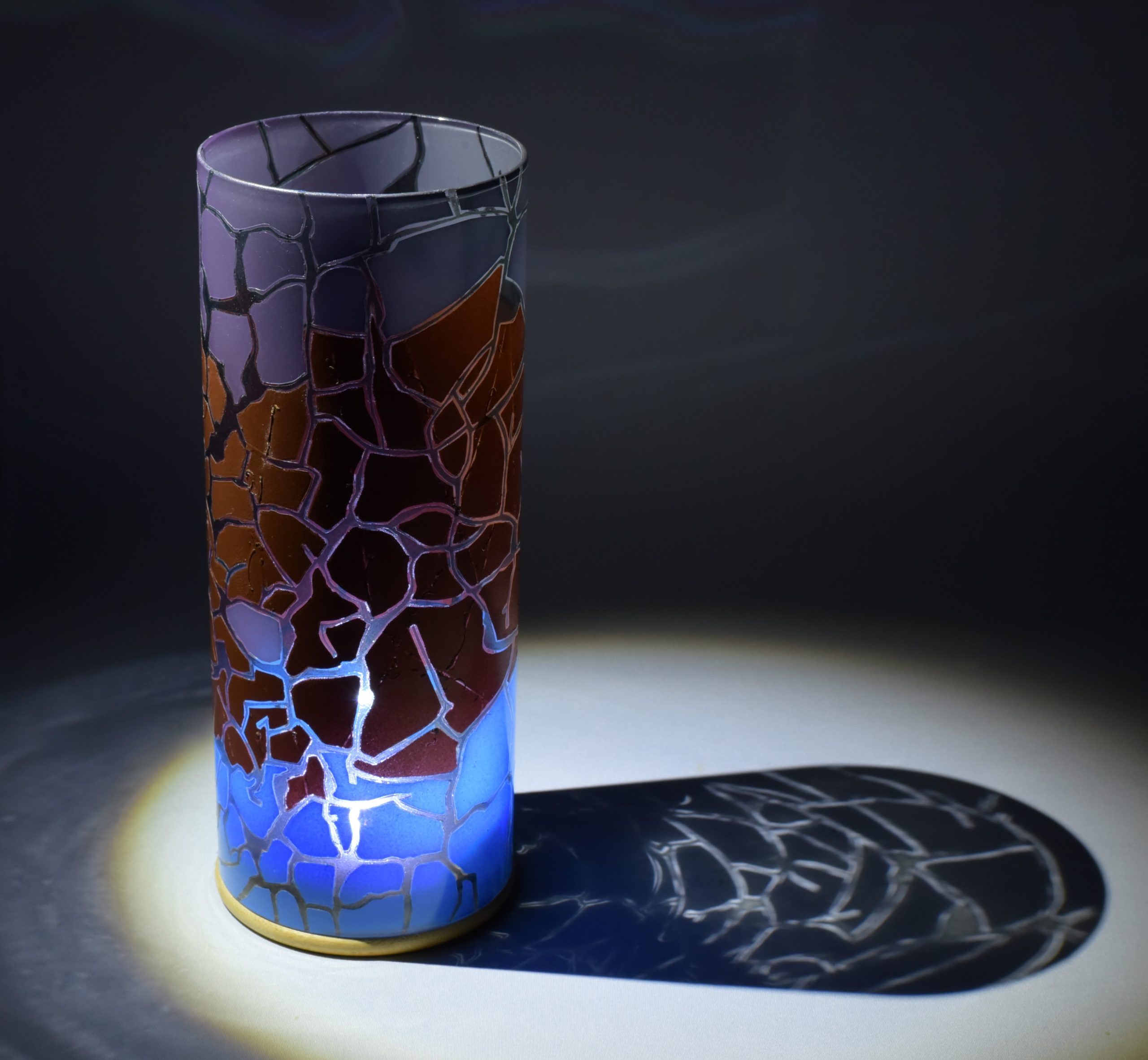 Unique accent lamp shown under spot light at upper left. Photo displays projected patterns in shadow of lamp.