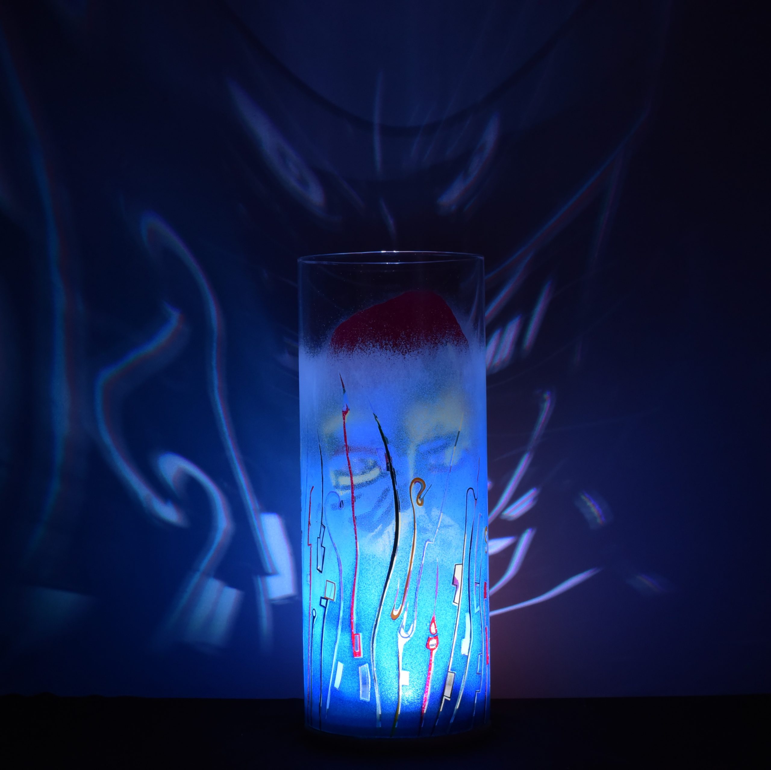 Shown with only LED illuminated. One-of-kind art accent lamp displays brilliant patterns on backdrop.