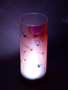 Accent lamp shown with only LED illuminated dramatically standing against a grey backdrop.